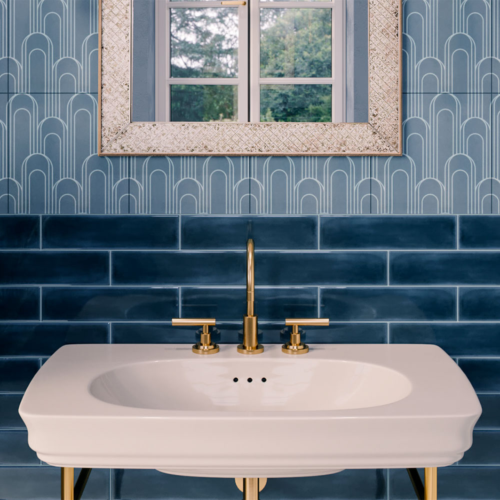 A close up of an elegant bathroom vanity featuring glossy dark blue subway tiles.